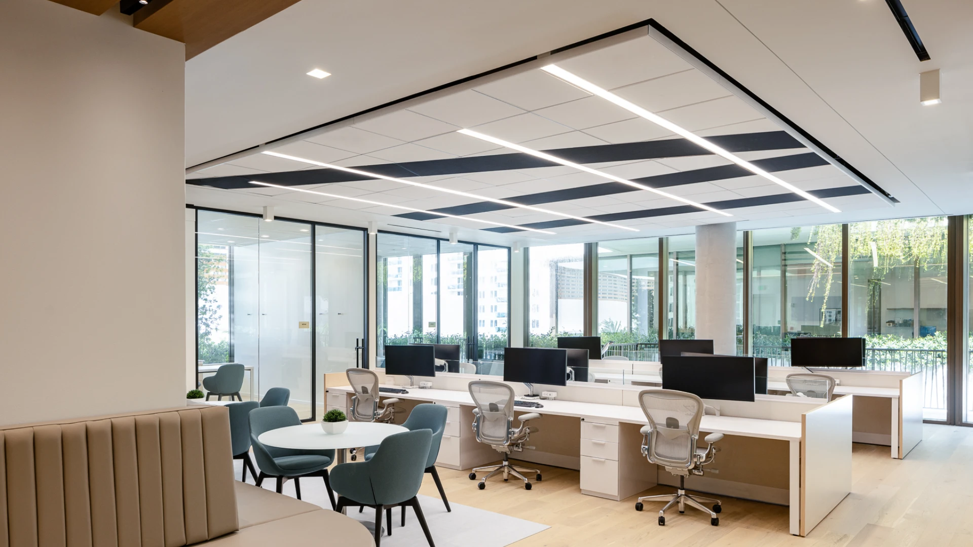 Modern startup office interior featuring an open-plan workspace, sleek white desks, ergonomic chairs, collaborative seating, integrated lighting, and floor-to-ceiling windows creating a bright, contemporary, and productive atmosphere.